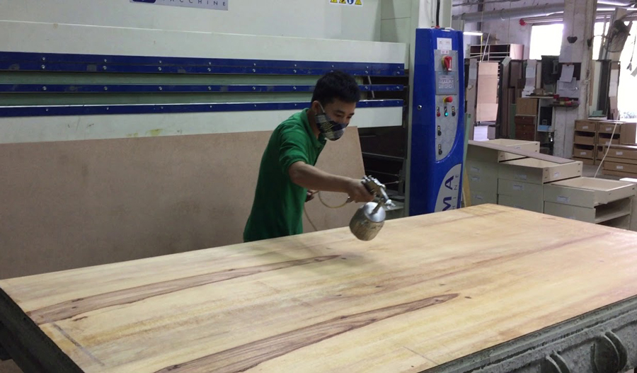 Hình ảnh công nhân đang dán tấm Laminate bằng keo phun